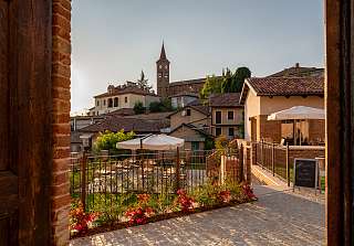  Sunstar Hotel PiemontView through a historic wooden door onto the terrace and village with church tower at Sunstar Hotel Piemont