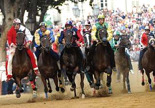 Jockeys en maillots colorés courant à cru lors de la course historique du Palio à Asti, près de l'Hôtel Sunstar Piemont